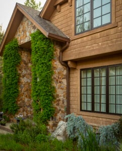 KGuard installed on home with brown siding and stone accents. Well maintained landscaping and bushes. Gutters protecting landscaping. Well maintained yard