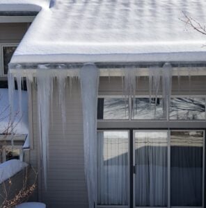 Icicles and ice damming present on gutters/roofline. Open Gutters in snow and ice