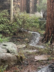 Water from downspout causing erosion during heavy rain. Downspout Placement is important. Water erosion trench. Streaming water