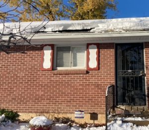 Brick house with snow on roof. Solar panels are under the snow. Heat cable in KGuard Gutters is keeping the snow from avalanching from the roof. Solar Panel Snow Slides didn't effect KGuard Gutters. 