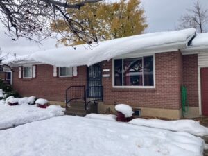 Brick home covered in snow. Solar panels on roof. Snow is avalanching from roof due to the solar panels warming faster than the roof. No Heat Cable. Before Heat Cable. KGuard is the solution for solar panels causing snow to avalanche. Solar panel snow slides.