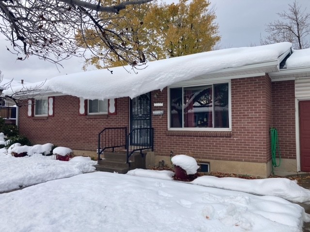 Brick home covered in snow. Solar panels on roof. Snow is avalanching from roof due to the solar panels warming faster than the roof. No Heat Cable. Before Heat Cable. KGuard is the solution for solar panels causing snow to avalanche. Solar panel snow slides.