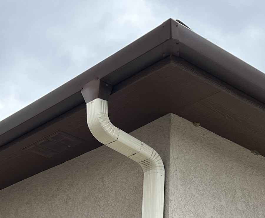 Seamless gutter corner and downspout outlet on a stucco home in the Colorado Springs area