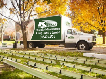 Photo of chop truck in front of home. fall trees in background. gutters are laid out on the front lawn with brackets set inside at every 2 feet.