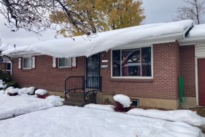 Brick home covered in snow. Solar panels on roof. Snow is avalanching from roof due to the solar panels warming faster than the roof. No Heat Cable. Before Heat Cable. KGuard is the solution for solar panels causing snow to avalanche. Solar panel snow slides.