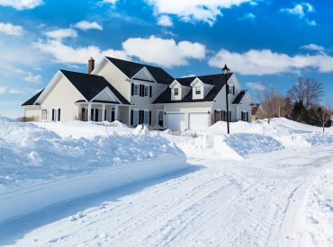 Street view of a house surrounded by snow