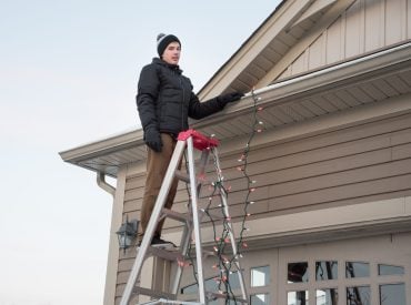 man hanging Christmas lights